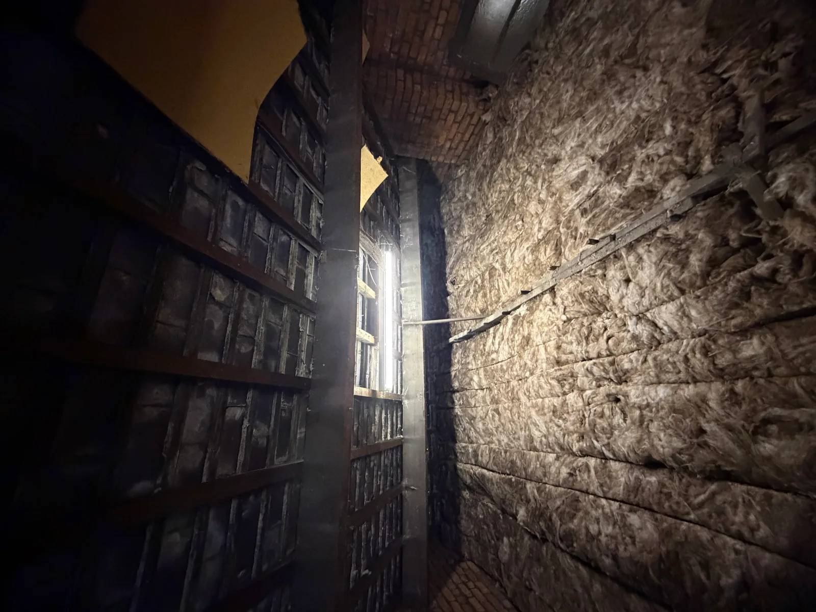 Loft bay fully insulated in mineral wool against an old slate roof structure